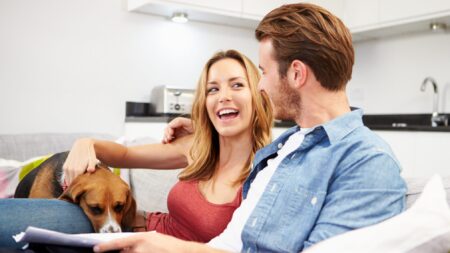 Couple at home with dog looking through finances