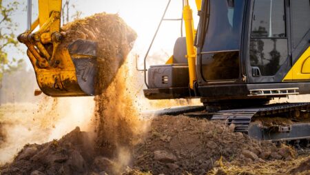 Excavator digging soil at construction site