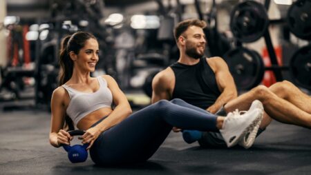 Fitness couple kettlebell twist in gym