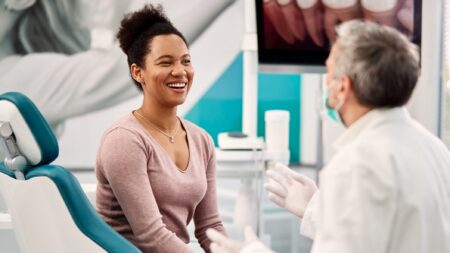 Happy dental patient talking with dentist