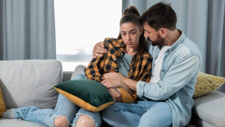 Man supporting grieving woman