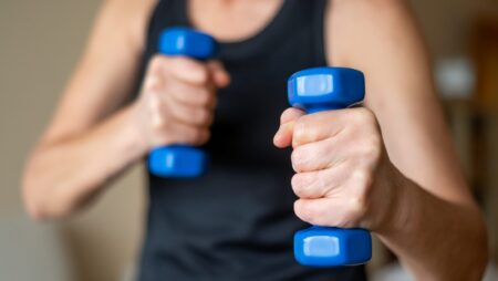 Person holding blue dumbbells