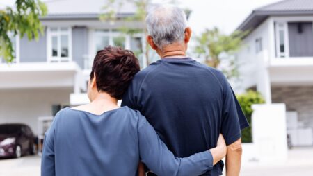 Senior couple outside looking at home estate transition