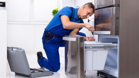 Serviceman repairing refrigerator