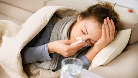 Sick woman with cold sneezing