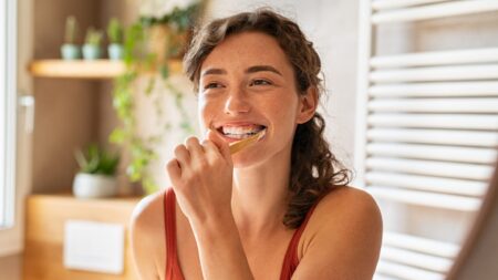 Smiling woman brushing teeth