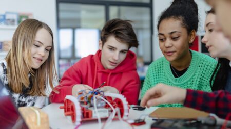 Students building toy classroom robotics