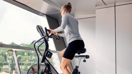 Woman exercising on stationary bike in fitness center