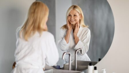 Woman looking into bathroom mirror