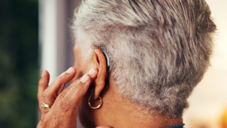 Woman putting in hearing aid