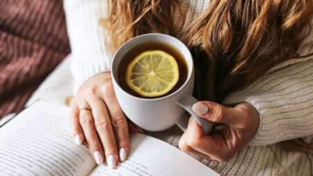 Woman relaxing with hot tea and book