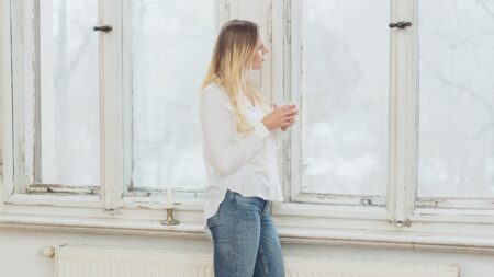 Woman staring outside window in winter mental wellness