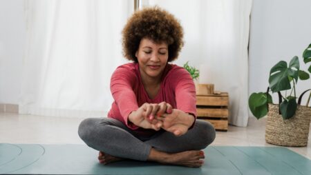 Woman stretching doing yoga at home wellness