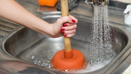 Woman with plunger clogged drain