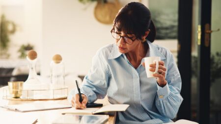 Woman writing in journal planning finances