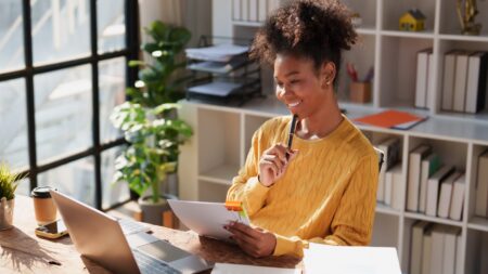Young woman reviewing financial documents at desk