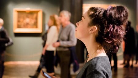 Young women waching arts at the museum. Excursion with group