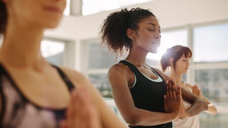 Woman practice yoga with friends in gym