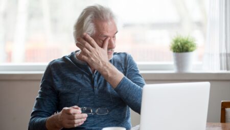 Fatigued mature man taking off glasses suffering from tired eyes