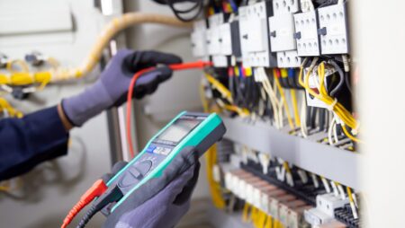Electrician engineer tests electrical installations and wires on