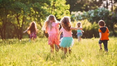 Large group of kids, friends boys and girls running in the park