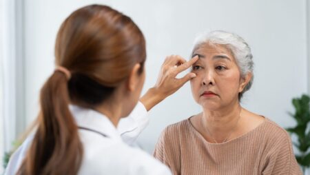 Doctor performing eye exam on senior female patient