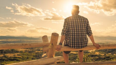 Thoughtful young man sitting in a peaceful nature setting.