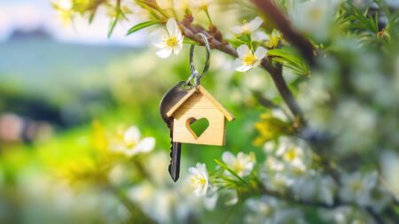 House key on blooming branch spring real estate