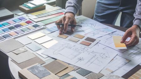Interior designer with color samples drawing blueprint