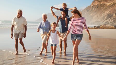Multi generation family walking on beach