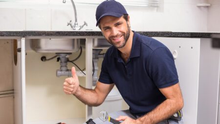 Plumber working under sink