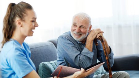 Senior man laughing with assisted living nurse