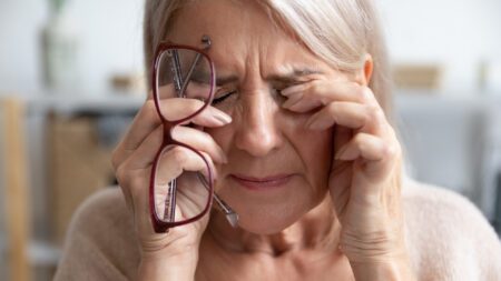 Senior woman rubbing eyes glasses