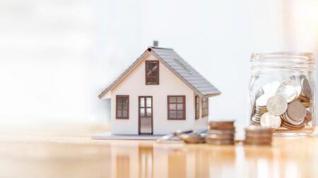 Small house and coin jar on table