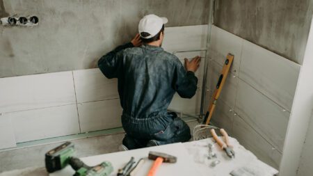 Worker securing ceramic tiles shower and bath remodel