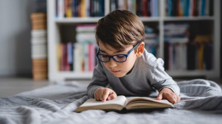 Young boy reading on floor