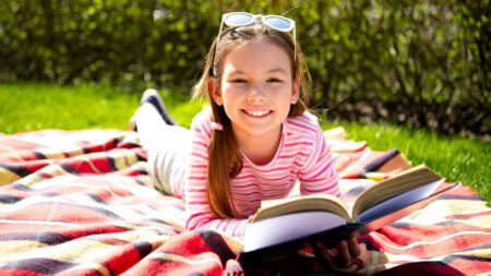 Young girl reading outside in summer