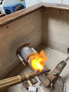 Ross Goldsmith melting the metal to fill the mold