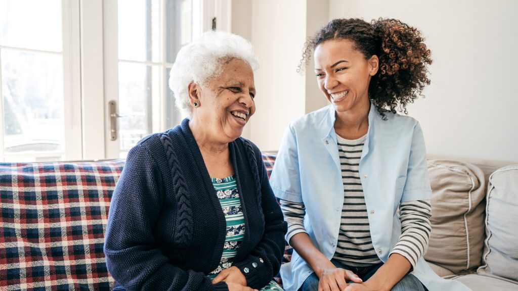 Caregiver laughing with senior woman Issaquah Memory Care