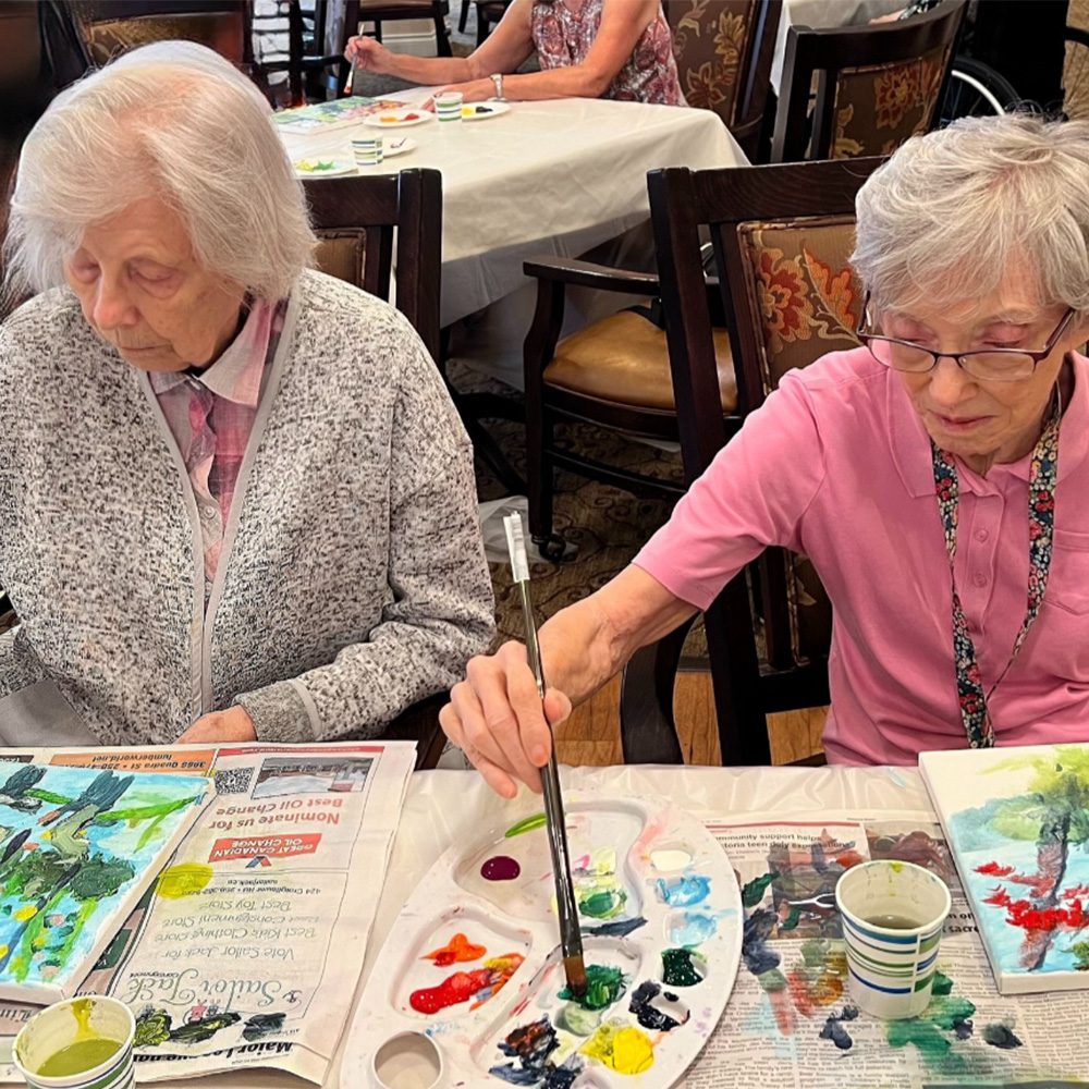 Senior women painting together Sunrise of Lynn Valley