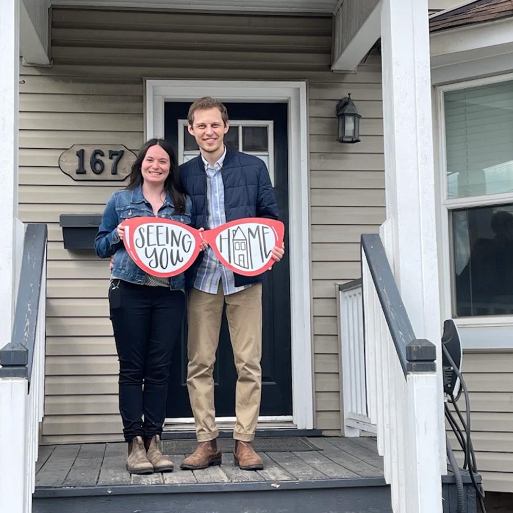 Couple on porch of new home RE MAX Twin City Realty - Seeing You Home