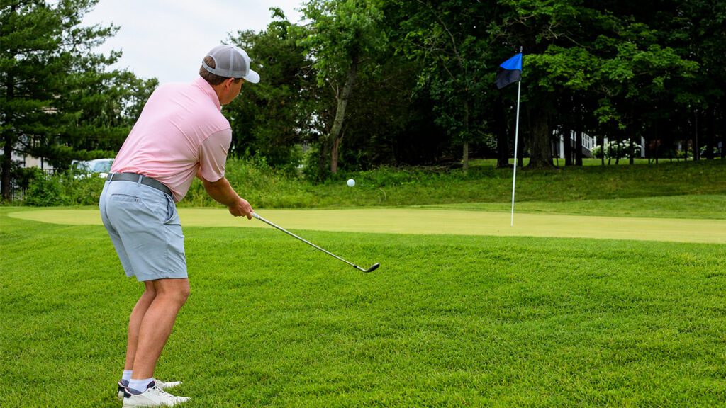 Golfer chipping Fore the Heroes Charity Golf Outing Menninger & Associates Financial Planning