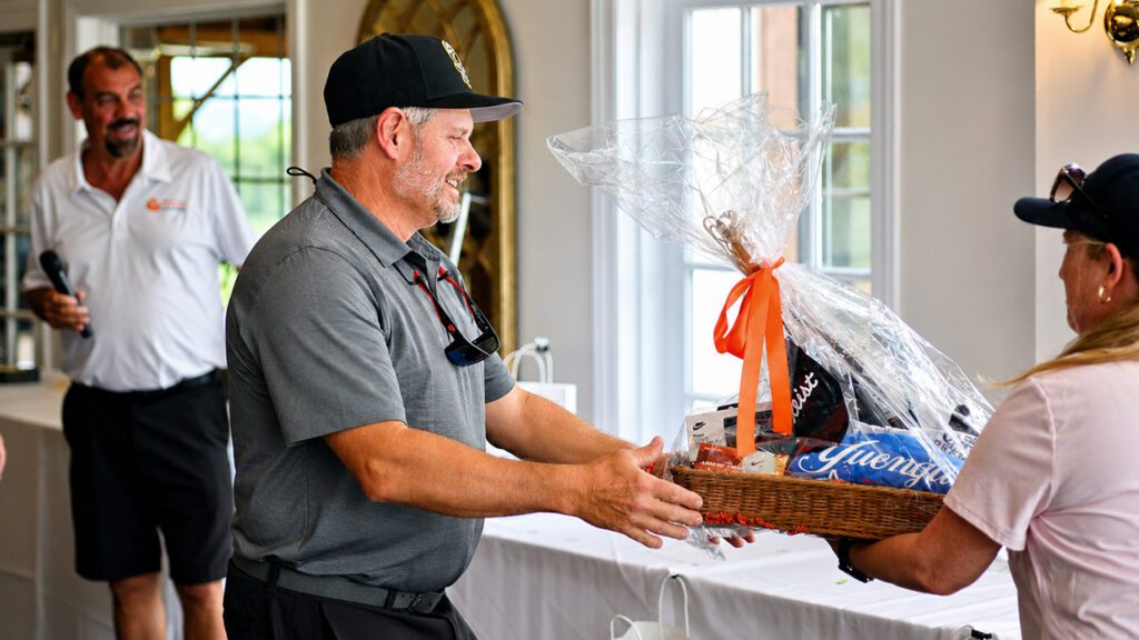 Golfer receiving prize Fore the Heroes Charity Golf Outing Menninger & Associates Financial Planning