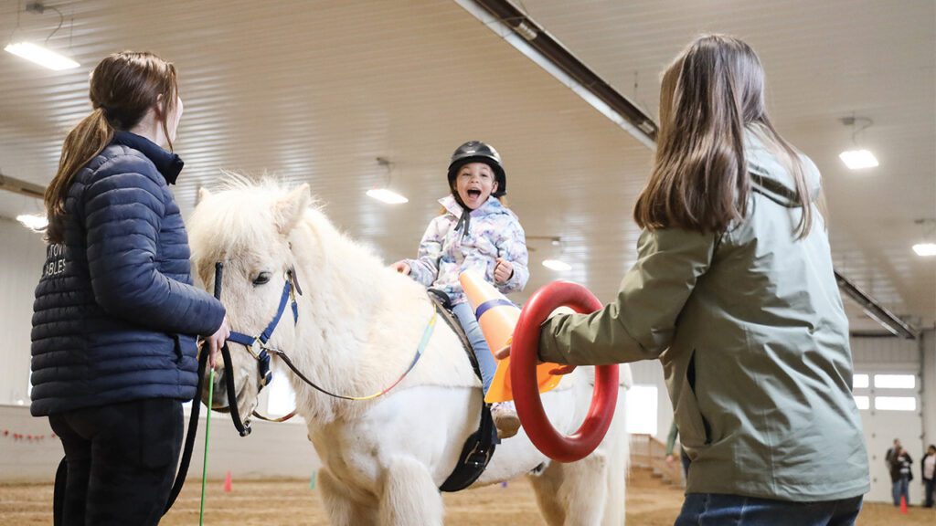 Young girl riding white horse Hestovin Stables Therapeutic Riding Center