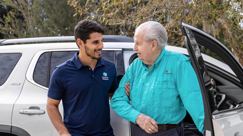 Caregiver assisting senior man out of vehicle Comfort Keepers (Corfield)