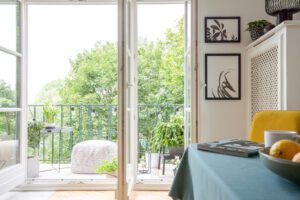Kirsten Reilly Real Estate LLC View from a room interior on a balcony and trees